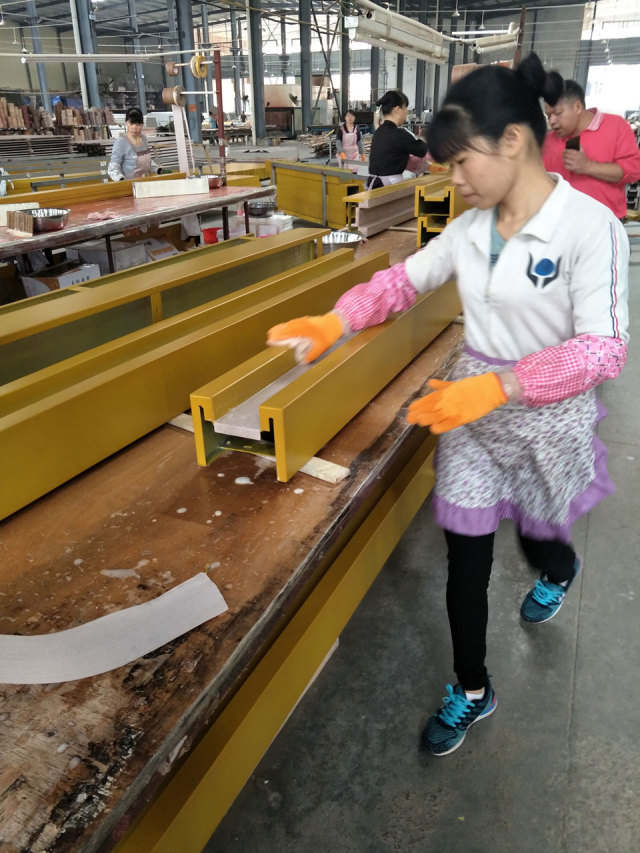 工人正在给喷粉处理后的铝单板做润湿处理